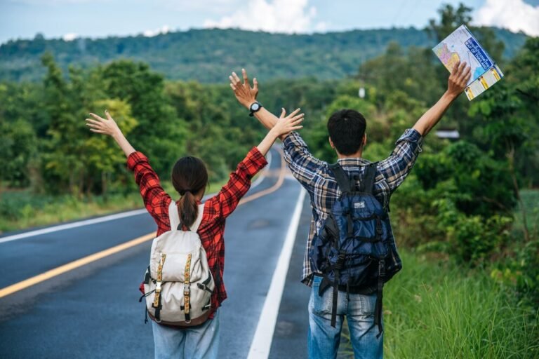 both-male-female-tourists-carry-backpack-stand-road-raise-their-hands-both-sides_1150-24549